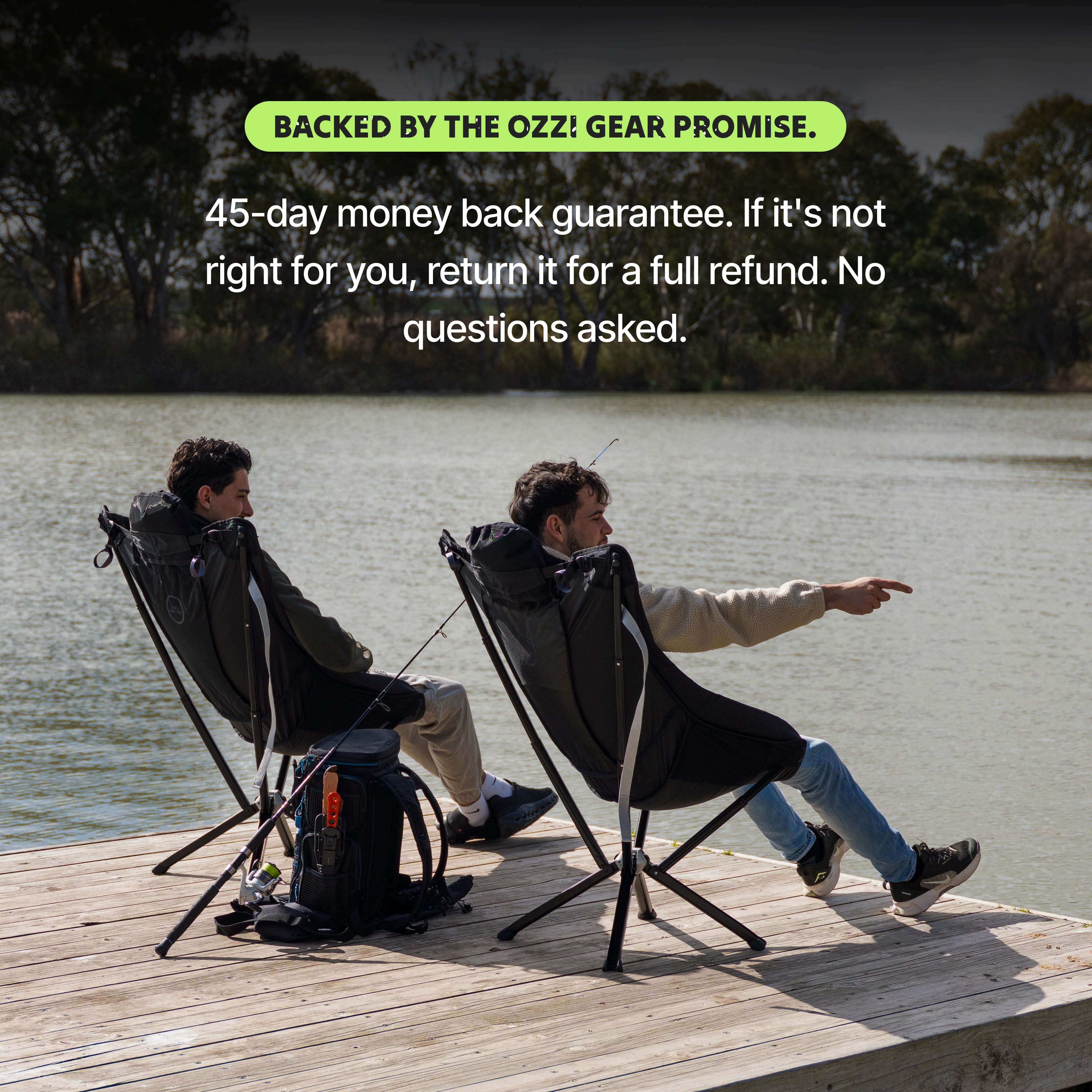 Two people sitting on Ozzi Gear Lounger camping chairs by a lake.
