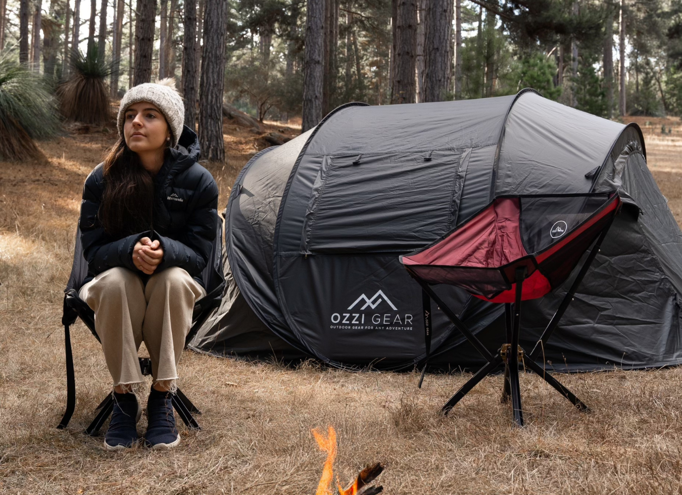 Woman sitting on camping chair infront of tent in forrest