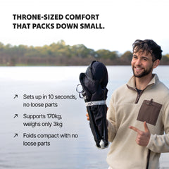 Man holding a foldable Ozzi Outdoor Lounger by a lake 