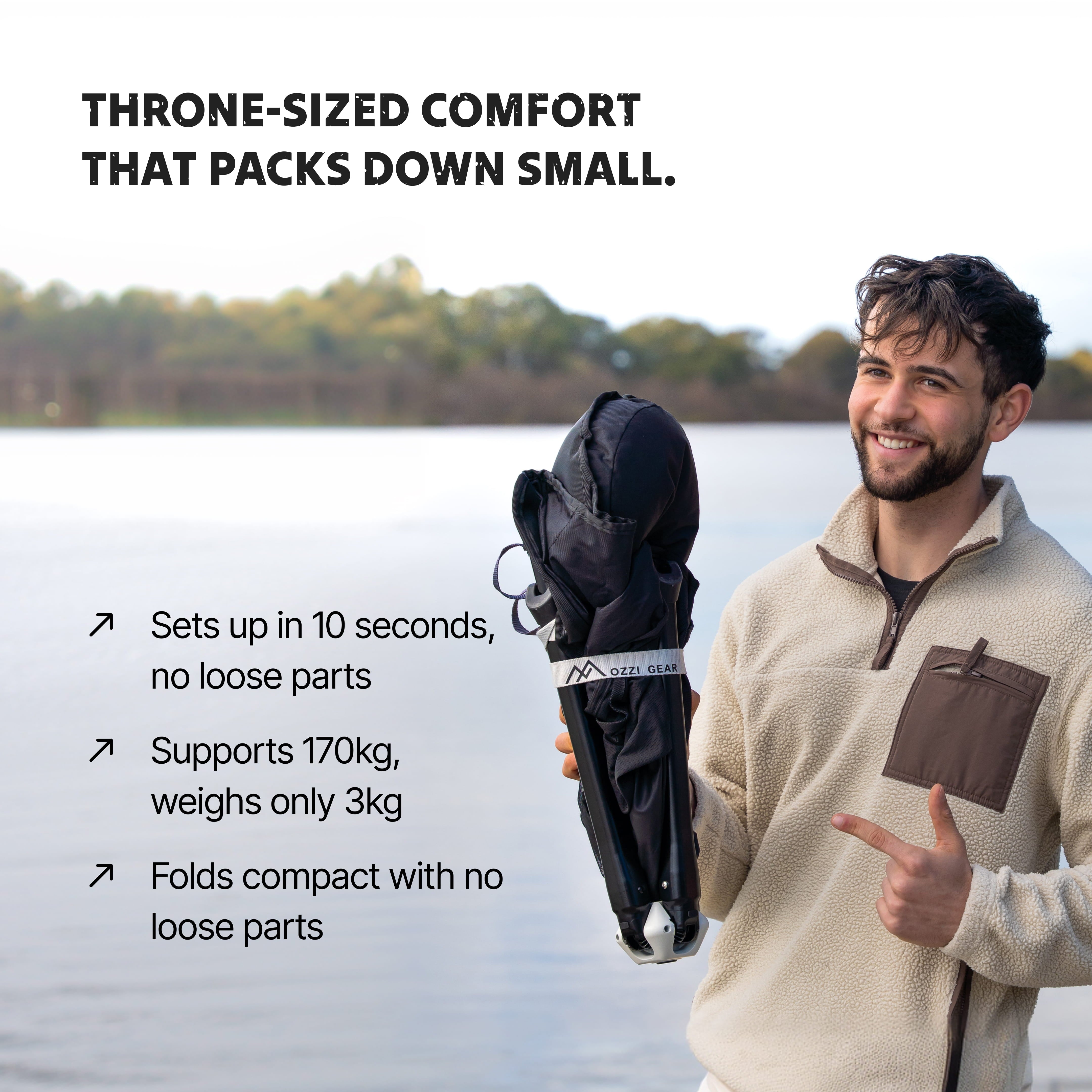 Man holding a foldable Ozzi Outdoor Lounger by a lake 
